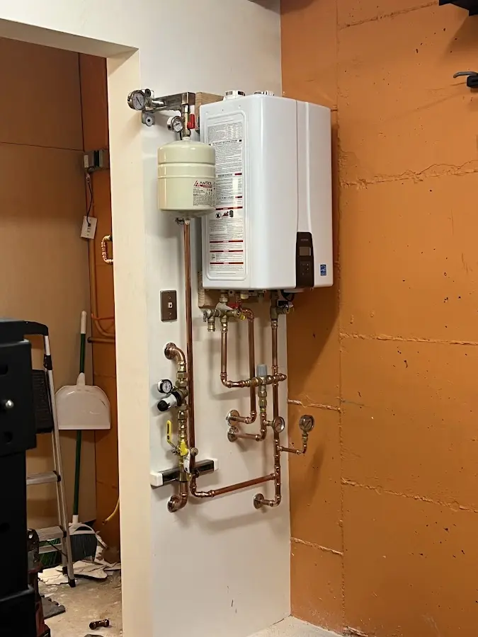 Plumbing technician inspecting water heater connections in Dayton